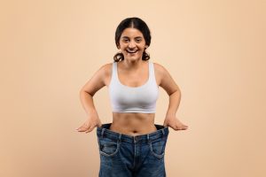 woman showing weight loss in old pants